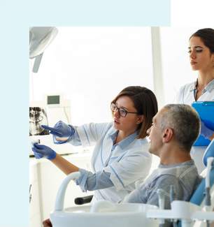 An orthodontist and a dentist explaining the procedure of wearing aligners to a male patient.
