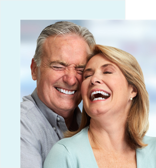 Elderly couple smiling with aligned teeth, hugging each other.
